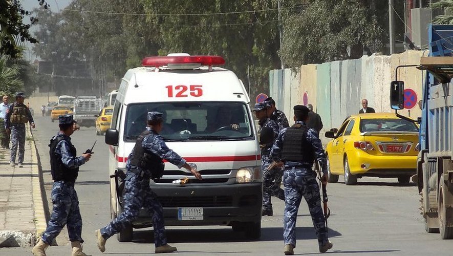 Une ambulance entourée de policiers à Kirkouk dans le nord de l'Irak, le 23 avril 2013