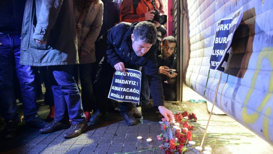 Un homme allume une bougie, le 20 mars 2016 dans le centre d'Istanbul, au lendemain d'un attentat qui a tué quatre personnes
