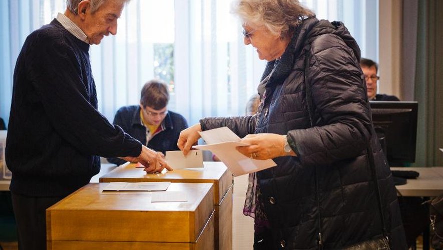 Une femme dépose son bulletin dans l'urne le 9 février 2014 à Ascona, en Suisse