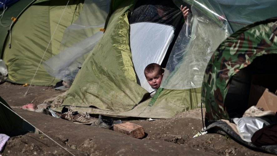 Un enfant sort sa tête d'une tente dans le camp de réfugiés de Idoméni, à la frontière entre la Grèce et la Macédoine, le 19 mars 2016