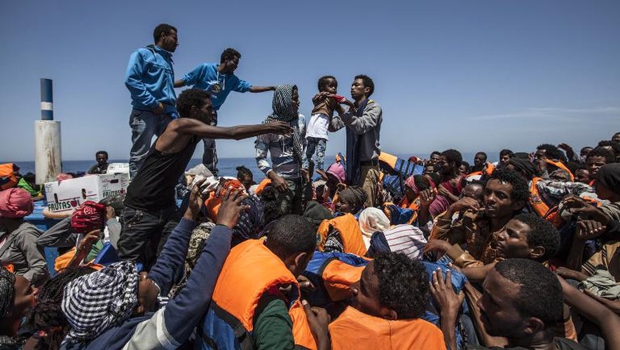 Des migrants à bord d'une embarcation en bois attendent d'être secourus au large de la Sicile, le 3 mai 2015