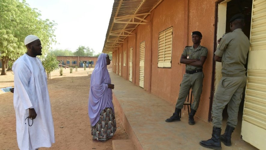 Des policiers nigériens surveillent l'entrée d'un bureau de vote à Niamey, le 20 mars 2016