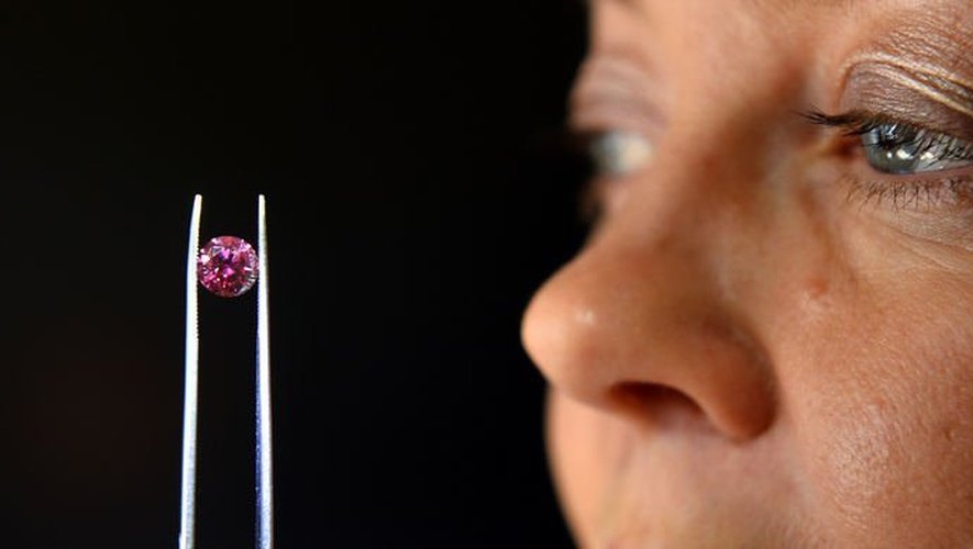 La responsable des enchères d'Argyle Pink Diamonds, Josephine Johnson, inspecte un diamant rouge le 17 mai 2013 à Sydney