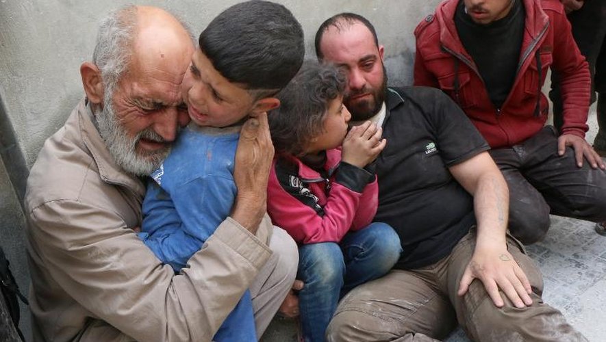 Des familles syriennes lors d'un bombardement des forces du régime le 29 avril sur Alep