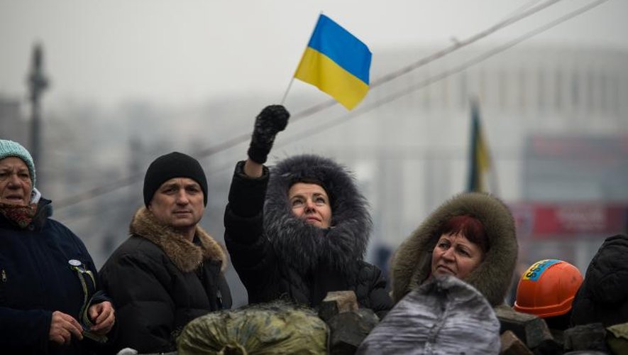 Une femme tient un drapeau ukrainien sur une barricade à Kiev, le 9 février 2014