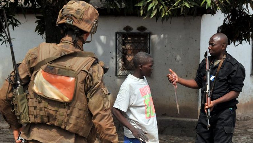 Un soldat français de l'opération Sangaris et un gendarme centrafricain confisquent un couteau à un homme, le 9 février 2014 à Bangui