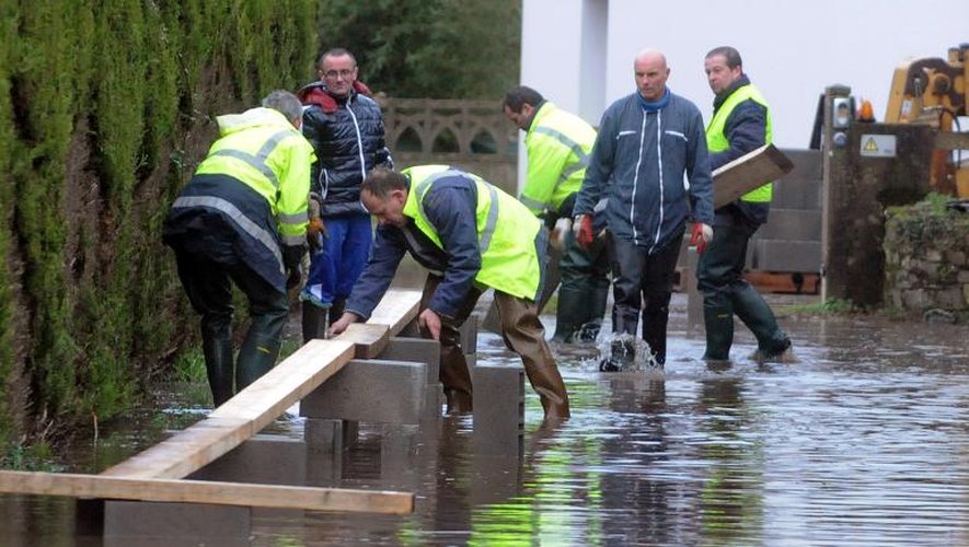 Des employés municipaux érigent un passage dans une rue inondée le 9 févier 2014 à Redon