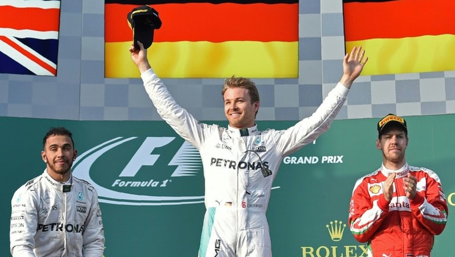 L'Allemand Nico Rosberg (Mercedes) bras levés sur le podium, fête sa victoire au GP d'Australie devant son coéquipier Lewis Hamilton (g) et Sebastian Vettel (Ferrari), le 20 mars 2016 à Melbourne