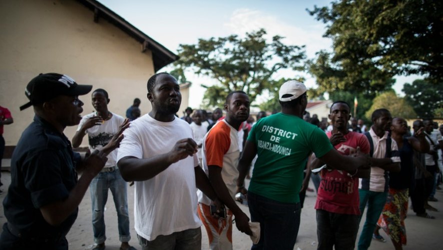 Un policier congolais tente de calmer des électeurs en colère dans le quartier Makelekele à Brazzaville le 20 mars 2016