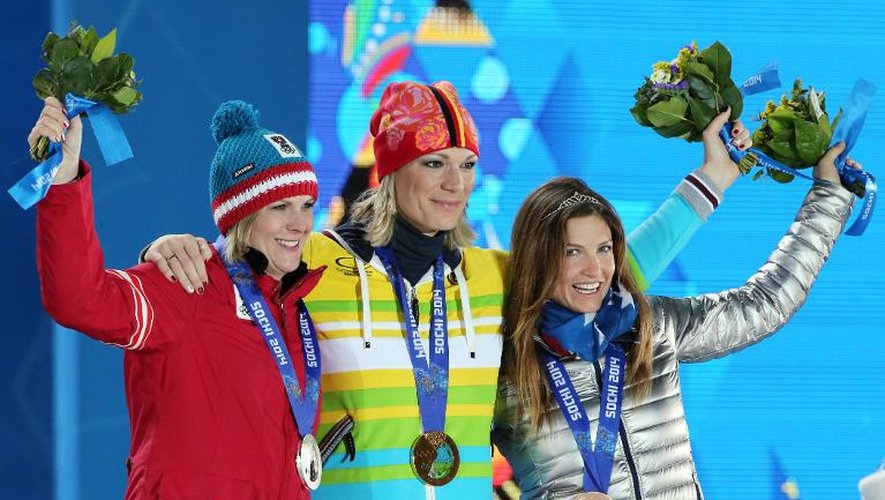L'Allemande Maria Hoefl-Riesch (C) entourée par l'Autrichienne Nicole Hosp (G) et l'Américaine Julia Mancuso (D), sur le podium du combiné de ski alpin aux JO de Sotchi, le 10 février 2014