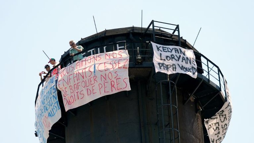 Trois pères déploient de bannières le 6 juillet 2013 sur une cheminée haute de 70 mètres à Grenoble, réclamant leur droit de visite à leurs enfants