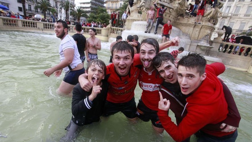 Des supporteurs de Toulon après la victoire de leur équipe en Coupe d'Europe de rugby fêtent la victoire dans une fontaine de Toulon le 18 mai 2013