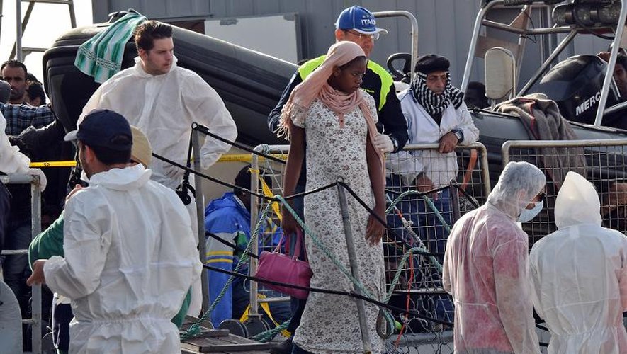 Une femme débarque d'un navire militaire dans le port de Messina le 6 mai après une opération de sauvetage des gardes-côtes italiens 
en Méditerranée