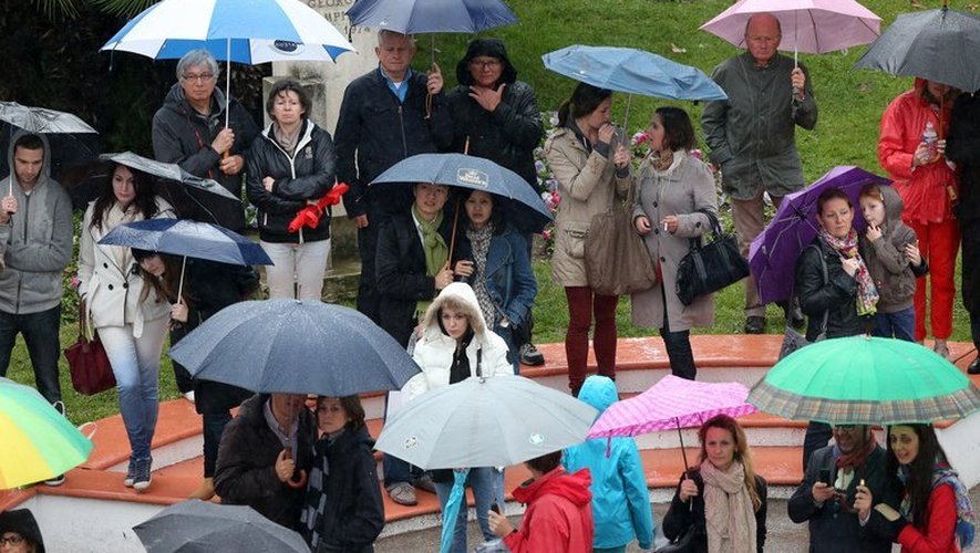 Des personnes regardent les stars monter les marches du Palais des festivals de Cannes sous des parapluies, le 18 mai 2013