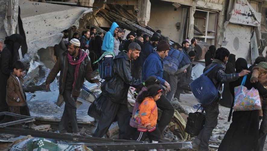 Des Syriens attendent d'être évacués des quartiers assiégés de Homs, lors d'une opération humanitaire, le 10 février 2014