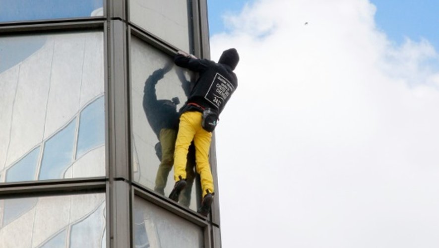 Le "Spiderman français", Alain Robert, sur la tour Total du quartier d'affaires de la Défense, le 21 mars 2016