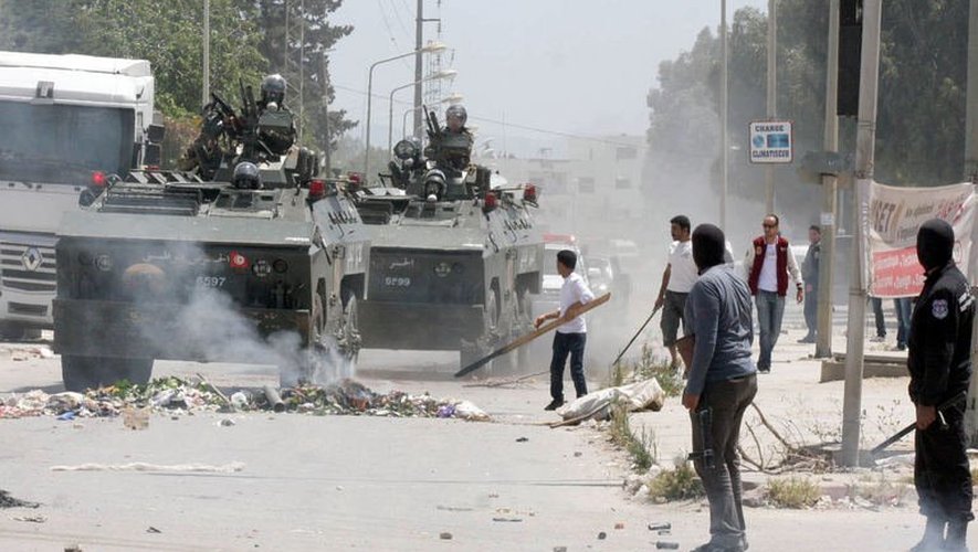 La police tunisienne lors de heurts avec des salafistes à Ettadhamen, à l'ouest de Tunis, le 19 mai 2013