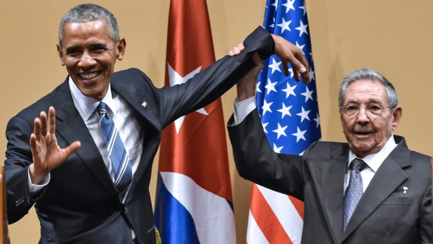 Le président cubain Raul Castro lève la main du président américain Barack Obama à La Havane, le 21 mars 2016