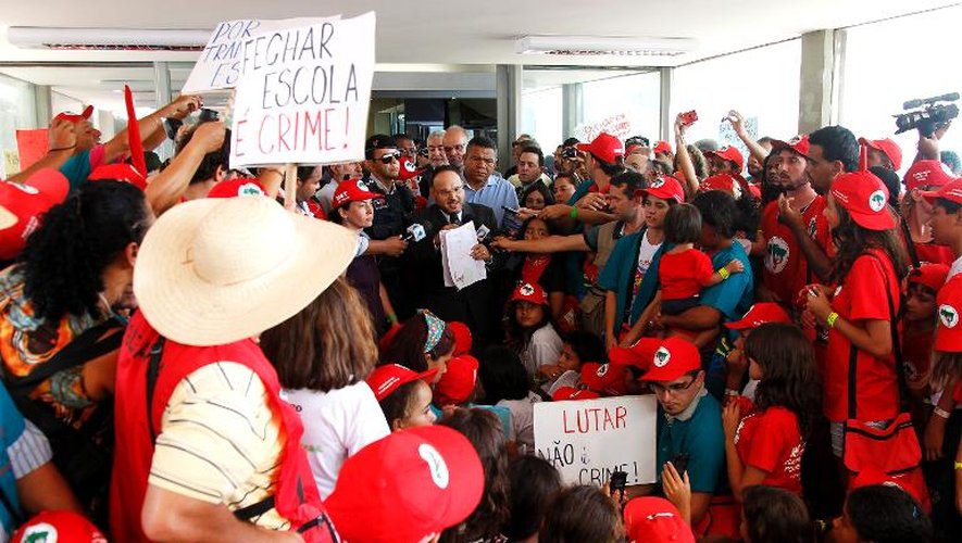 Le ministre brésilien de l'Education, Henrique Paim parle avec des membres du Mouvement des travailleurs ruraux sans terre (MST) qui occupent son ministère à Brasilia, le 12 février 2014