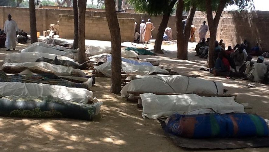 Des habitants se tiennent près des cadavres prêts à être inhumés dans le village de Konduga, dans le nord-est du Nigeria, le 12 février 2014, après une attaque du groupe islamiste Boko Haram