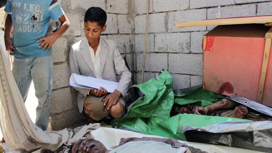 Un jeune garçon veille le 6 mai 2015 un combattant mort lors d'affrontements avec les rebelles chiites Houthis dans la ville de Taez