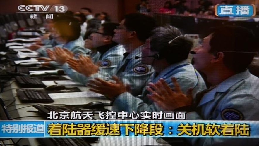 Capture d'écran de la chaîne chinoise CCTV montrant les ingénieurs du programme spatial applaudissant l'alunissage du Lapin de Jade, le 14 décembre 2013 à Pékin