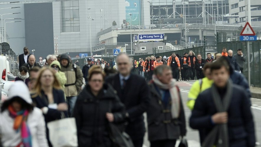La population évacue l'aéroport de Bruxelles, le 22 mars 2016, après deux explosions qui ont fait au moins 13 morts