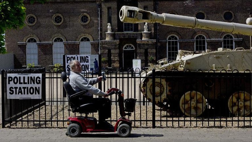 Un homme passe en chaise roulante électrique devant le Greenwich Heritage Centre transformé en bureau de vote, à Londres