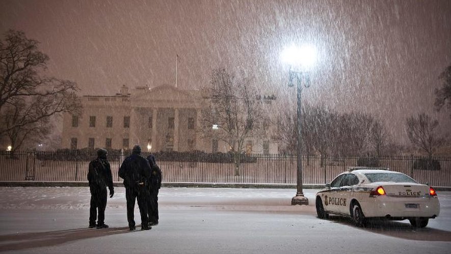 Des policiers devant la Maison Blanche pendant une chute de neige, le 13 février 2014 à Washington