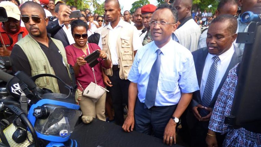 Le président de Madagascar Hery Rajaonarimampianina (2e d) montre le lingot d'argent qui pourrait provenir du trésor du "Capitaine Kidd", le 7 mai 2015 dans l'île de Sainte Marie