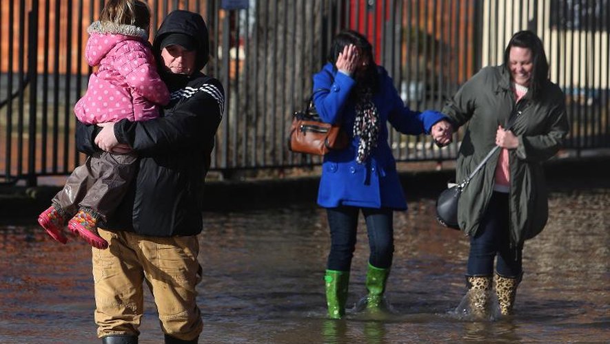 Des habitants de Worcester le 13 février 2014 dans une rue inondée de la ville