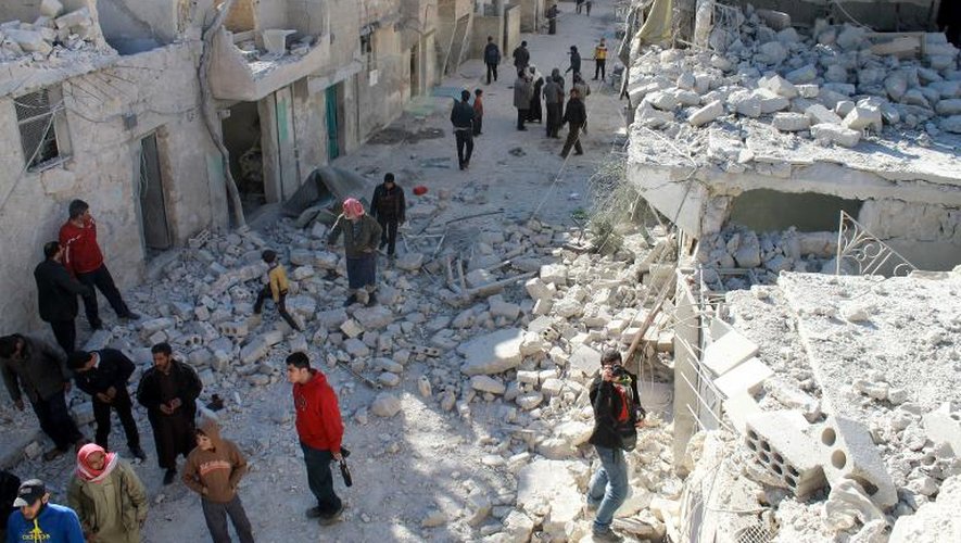 Des habitants au milieu des décombres de maisons après une attaque aérienne de l'armée syrienne, le 13 février 2014 à Alep