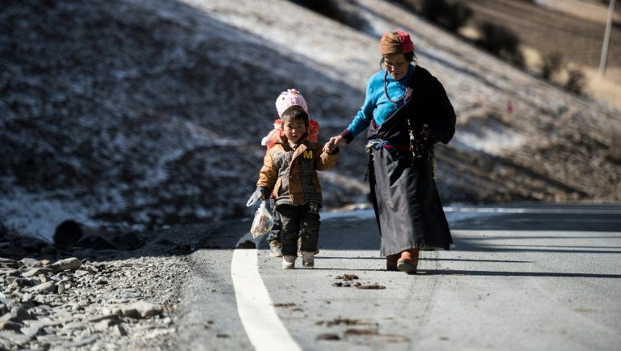 Une femme et ses enfants marchent le long d'une route à Dawu dans la préfecture autonome tibétaine de la province du Sichuan en Chine, le 8 décembre 2015