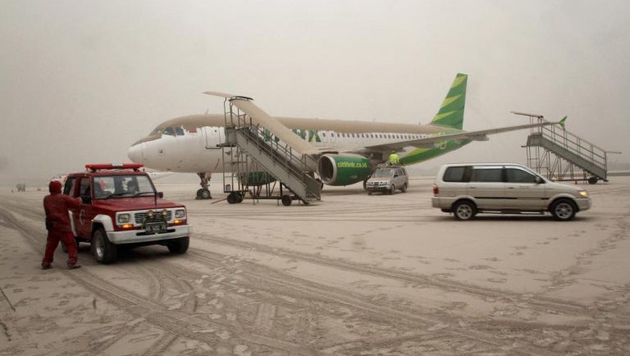 Un avion et le tarmac de l'aéroport de Yogyakarta recouverts de cendres après l'éruption du mont Kelud, le 14 février 2014 sur l'île de Java, en Indonésie