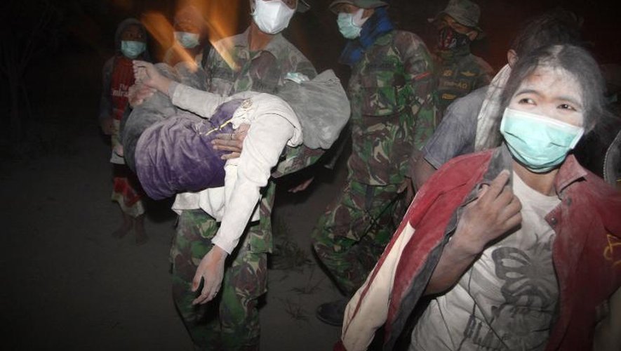 Des militaires aident des habitants à évacuer Malang, après l'éruption du Mont Kelud, le 14 février 2014 sur l'île de Java, en Indonésie