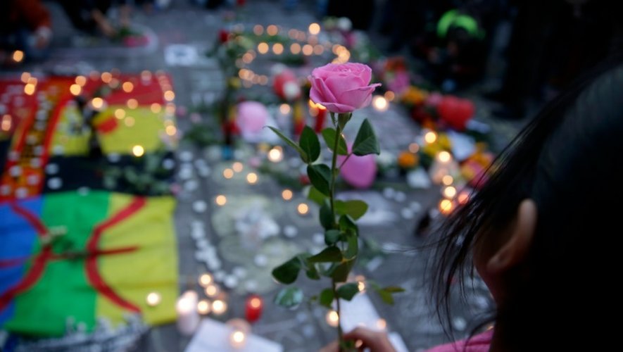 Une fillette tient dans ses mains une rose et se mêle aux hommages aux victimes des attentats, place de la Bourse à Bruxelles, le 22 mars 2016