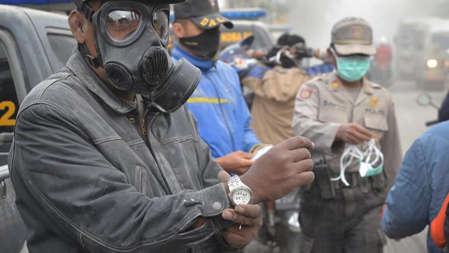 Des policiers distribuent des masques aux habitants de Malang, après l'éruption du mont Kelud, le 14 février 2014 sur l'île de Java, en Indonésie