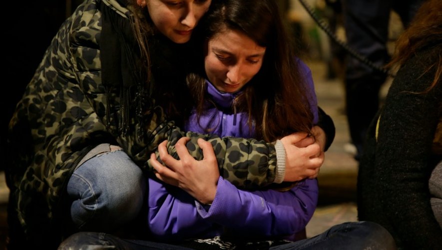 Deux jeunes femmes se réconfortent sur le lieu de recueillement qu'est devenue après les attentats la place de la Bourse à Bruxelles, le 22 mars 2016