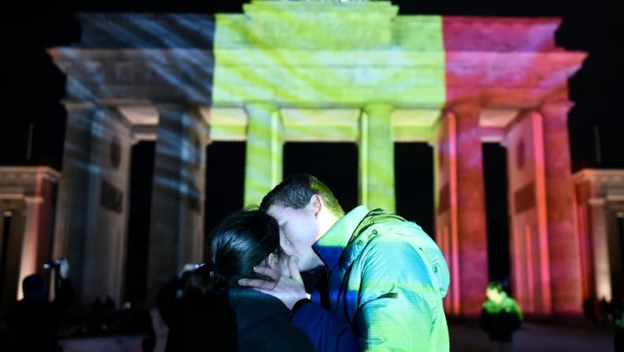 Un couple s'embrasse devant la porte de Brandebourg à Berlin, illuminée aux couleurs de la Belgique, en hommage aux victimes des attentats de Bruxelles
