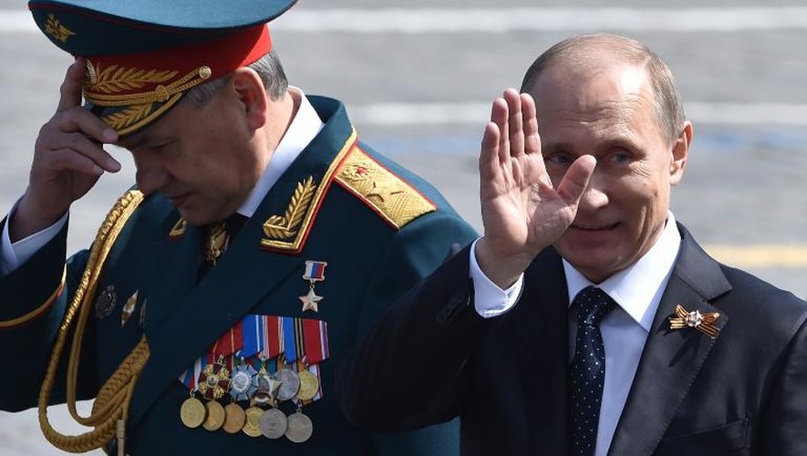 Le président russe Vladimir Poutine (d) et le ministre de la Défense Serguei Shoïgou quittent la place Rouge à Moscou après la parade militaire, le 9 mai 2015