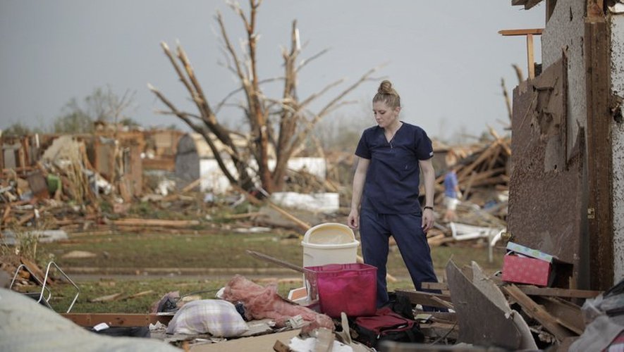 Une habitante de Moore regarde les débris de sa maison, dévastée par la tornade qui s'est abattue sur la ville, le 21 mai 2013