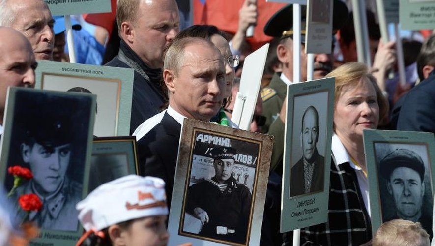 Le président russe Vladimir Poutine brandit, comme de nombreux autres participants, une photo de son père lors du cortège célébrant les 70 ans de la victoire sur Hitler