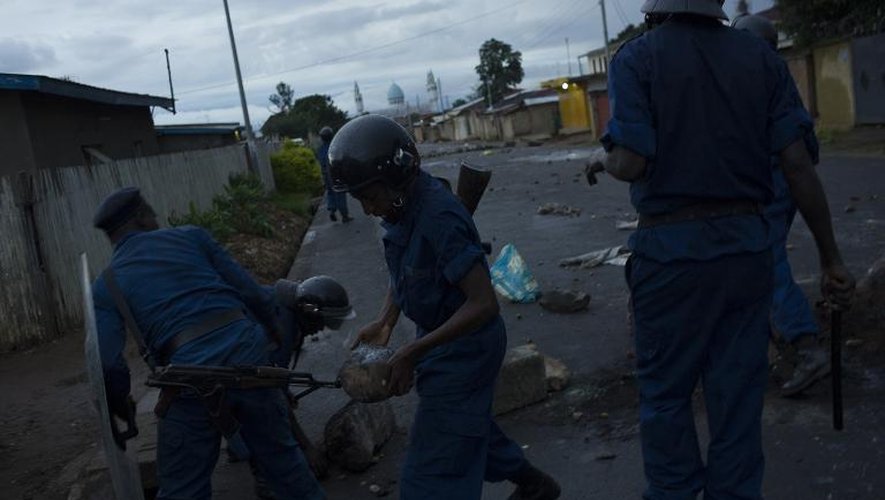 Des policiers détruisent une barricade après des affrontements avec les manifestants, le 8 mai 2015 à Nyakabiga, dans la périphérie de Bujumbura