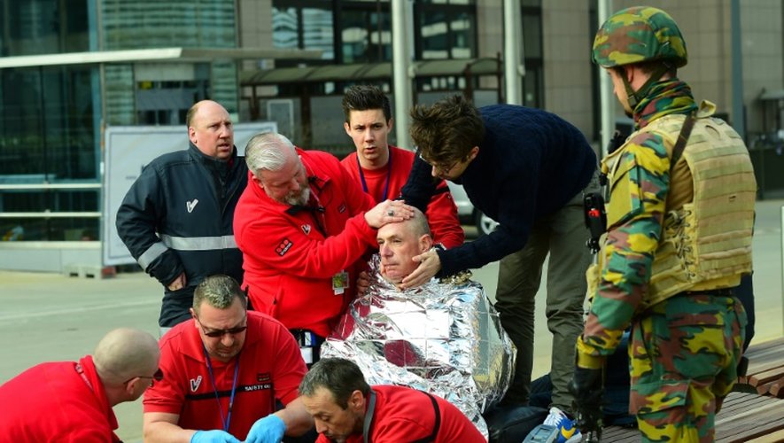 Une victime entourée des secouristes le 22 mars 2016 près de la station de métro de Maalbeek à Bruxelles