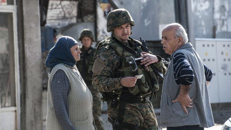 Un couple albanais attend la permission de passer un barrage dressé par la police à Kumanovo, au deuxième jour d'affrontements entre la police et un groupe armé, le 10 mai 2015, dans le nord de la Macédoine