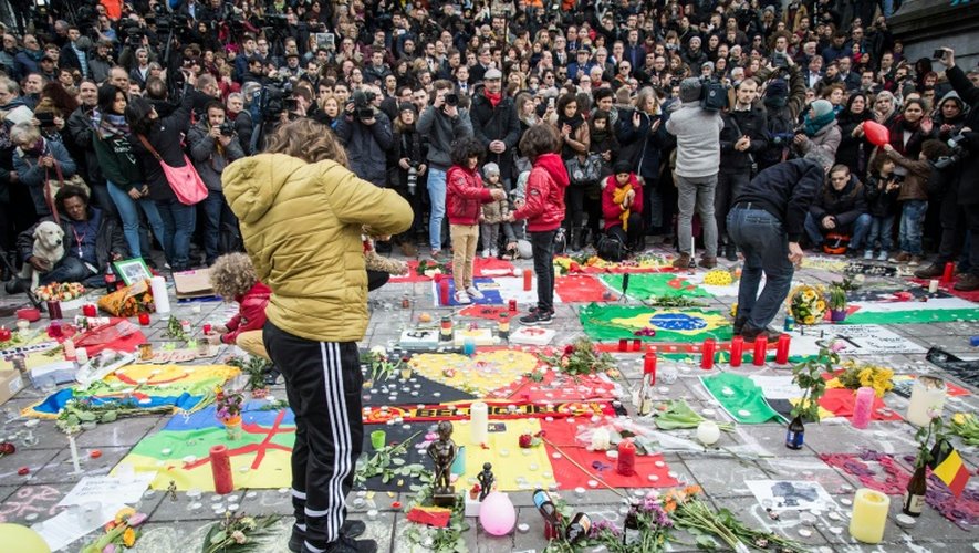 Une minute de silence est observée sur la Place de la Bourse à Bruxelles le 23 mars 2016 en hommage aux victimes des attentats qui ont frappé la veille la capitale belge