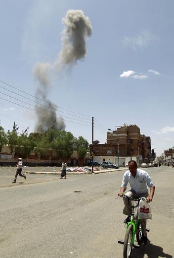 Des hommes fuient des bombardements, le 10 mai 2015 à Sanaa