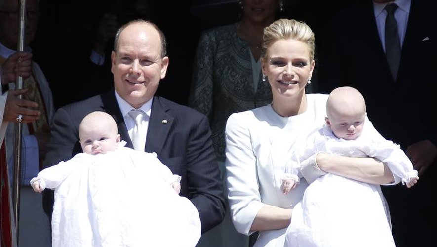 Le Prince Albert II de Monaco et son épouse Charlène tiennent leur jumeaux, à la sortie de la cathédrale à Monte-Carlo, après leur baptême, le 10 mai 2015