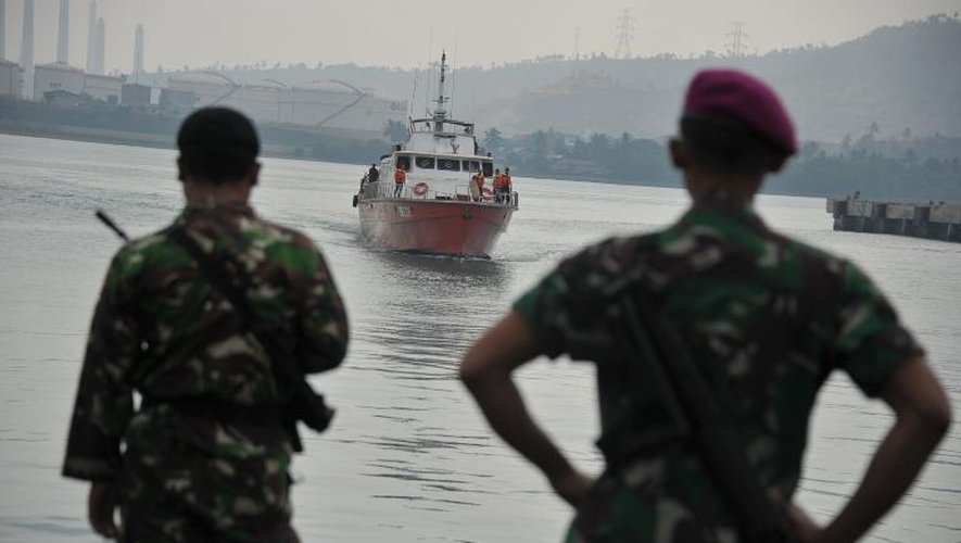 Des forces de l'ordre indonesiennes regardent un bateau d'immigrants s'approcher des côtes le 31 août 2012