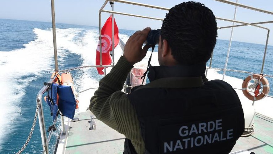 Un membre de la garde nationale tunisienne scrute la mer à la jumelle au large de Zarzis, dans le sud-est du pays, à la recherche de bateaux potentiellement chargés de migrants tentant d'atteindre l'Europe, le 5 mai 2015
